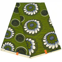 Un Ankara plié en tissu wax africain de Longan Craft France avec un imprimé floral audacieux en blanc, bleu et vert, et des accents orange sur le bord - le textile idéal pour les styles branchés.
