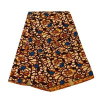 Un pli Longan Craft France Tissu wax africain Ankara avec des tourbillons noirs, un fond jaune orangé et des formes bleues est soigneusement disposé sur une surface blanche. Textile tendance d'Ankara, vendu au mètre pour divers styles vestimentaires.