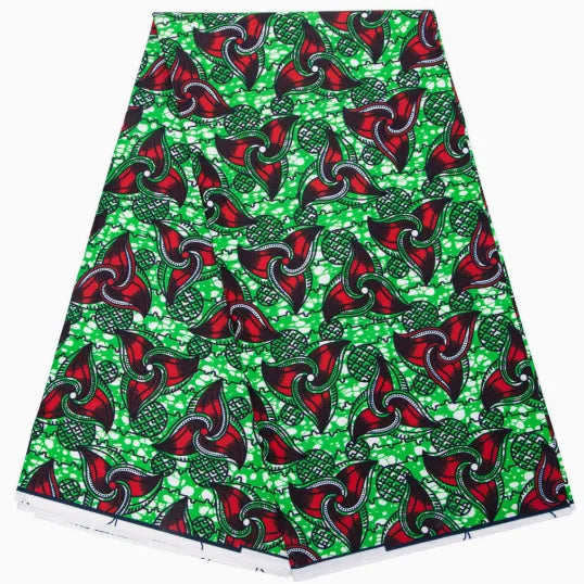 Un vibrant Longan Craft France Tissu wax africain Ankara coloré au mètre, avec des motifs rouges, verts et noirs rehaussés de points blancs, est présenté plié sur un fond blanc. Un textile tendance parfait pour divers styles de mode.