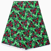 Un vibrant Longan Craft France Tissu wax africain Ankara coloré au mètre, avec des motifs rouges, verts et noirs rehaussés de points blancs, est présenté plié sur un fond blanc. Un textile tendance parfait pour divers styles de mode.