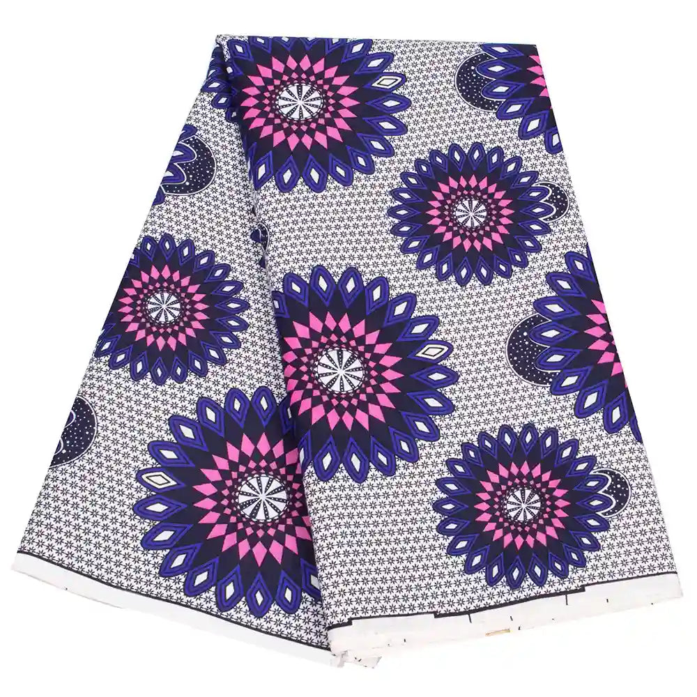 Le tissu wax africain Ankara coloré au mètre de Longan Craft France présente un motif géométrique répétitif avec de grandes formes circulaires ressemblant à des fleurs, en bleu, rose et noir sur blanc, idéal pour les styles textiles tendance.