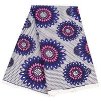 Le tissu wax africain Ankara coloré au mètre de Longan Craft France présente un motif géométrique répétitif avec de grandes formes circulaires ressemblant à des fleurs, en bleu, rose et noir sur blanc, idéal pour les styles textiles tendance.