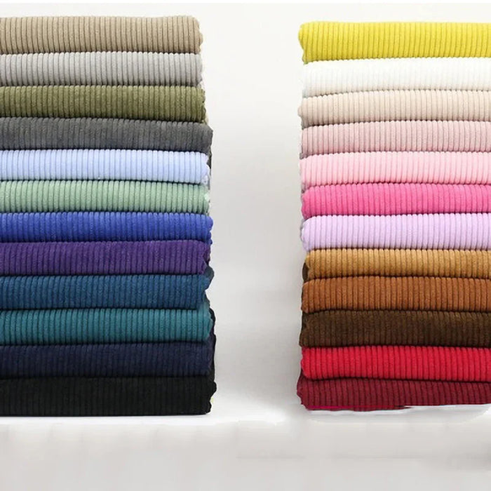 Deux piles de Velours côtelé coton 8 côtes uni au mètre de Longan Craft France en couleurs neutres, vives et pastel sont disposées côte à côte - idéales pour les vêtements, les accessoires ou les projets de décoration.