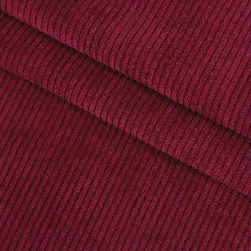 Un gros plan du Velours côtelé coton 8 côtes uni au mètre de Longan Craft France, en rouge foncé, révèle des stries verticales texturées, parfaites pour les vêtements, les accessoires ou les projets de bricolage décoratif.