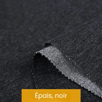 Gros plan sur un "Tissu denim coton au mètre" noir épais de Longan Craft France, montrant sa surface texturée et son bord brut sur un fond plat. Une étiquette jaune en bas indique "Épais, noir".
