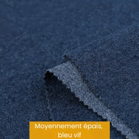 Deux morceaux superposés de Tissu denim coton au mètre bleu vif, d'épaisseur moyenne, de Longan Craft France, avec un bord en zigzag, sont présentés. Une étiquette jaune indique "Moyennement épais, bleu vif".