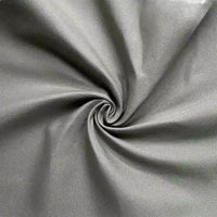 Gros plan sur la Gabardine de coton au mètre de Longan Craft France, un tissu gabardine sergée légère au tissage visible et à la texture lisse, disposé en spirale - une matière respirante idéale pour la confection de chemises.