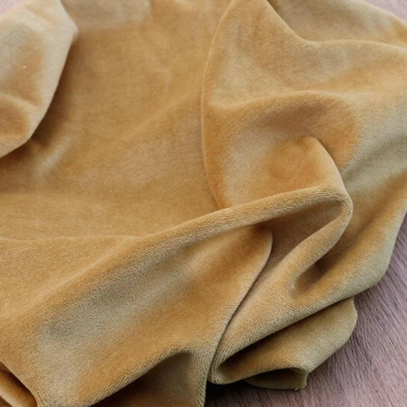 Gros plan sur Velours de coton et polyester doux au mètre de Longan Craft France drapé sur bois, mettant en valeur sa texture douce-idéal pour ameublement, habillement et projets couture.