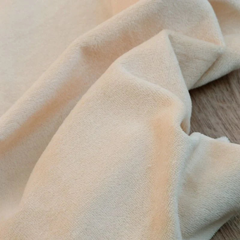 Gros plan sur Velours de coton et polyester doux au mètre de Longan Craft France, un tissu velours uni en maille, beige, à surface douce et légèrement texturée-idéal pour ameublement, habillement et projets de couture.