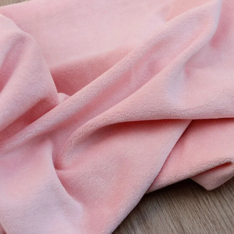 Le Velours de coton et polyester doux au mètre de Longan Craft France est un tissu doux, rose pâle, à la texture pelucheuse et lisse, parfait pour les projets de couture, d'ameublement et d'habillement.