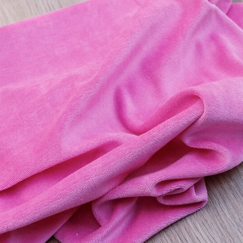 Gros plan sur le Velours de coton et polyester doux au mètre de Longan Craft France, un tissu doux et rose vif avec une texture veloutée et de légers plis, parfait pour l'ameublement, l'habillement et les projets de couture.