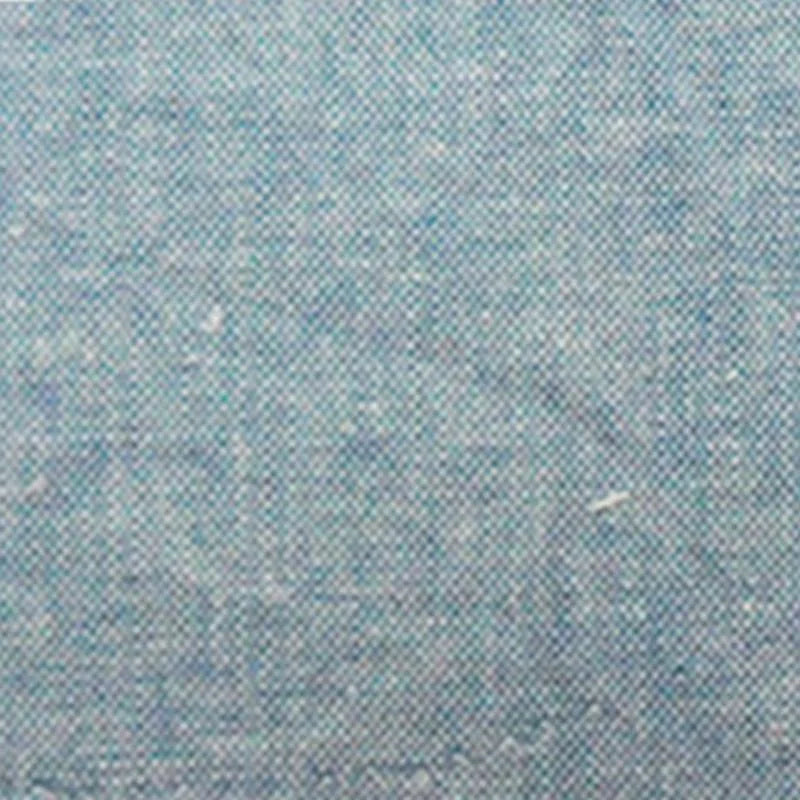 Gros plan sur le tissu chambray denim en coton au mètre de Longan Craft France, un tissu chambray bleu clair finement tissé, uni et subtilement moucheté, idéal comme tissu pour chemises d'été.