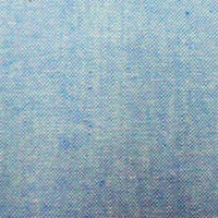 Gros plan sur le denim Tissu chambray en coton au mètre de Longan Craft France, qui présente une surface bleue fine avec des mouchetures uniformément réparties, idéale pour la confection de chemises d'été légères.