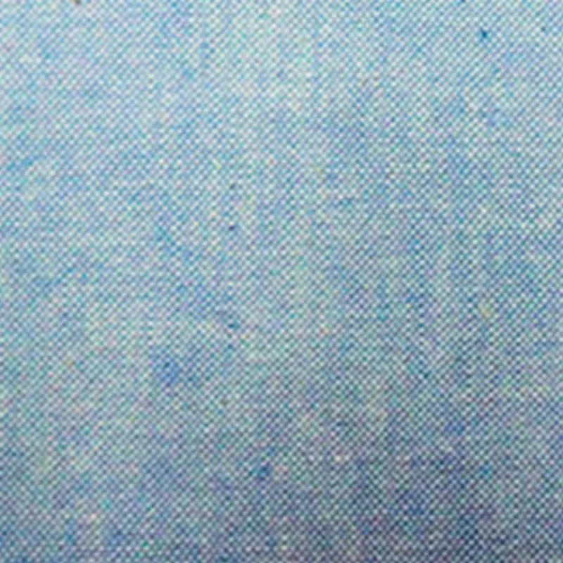 Gros plan sur le denim Tissu chambray en coton au mètre de Longan Craft France, qui présente une surface bleue fine avec des mouchetures uniformément réparties, idéale pour la confection de chemises d'été légères.