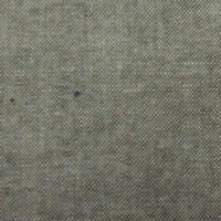 Gros plan sur le Tissu chambray denim en coton au mètre de Longan Craft France, un tissu de coton fin, gris-brun avec de petites taches foncées et un tissage visible, idéal pour les chemises d'été.
