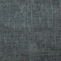 Un gros plan sur le Tissu chambray denim en coton au mètre de Longan Craft France révèle un tissage fin, gris et moucheté aux lignes subtiles - parfait comme tissu pour chemises d'été.