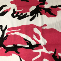 Un gros plan du Tissu camouflage en coton au mètre de Longan Craft France montre son motif camouflage abstrait noir, rose et blanc, parfait pour la confection de pantalons de style hip-hop.