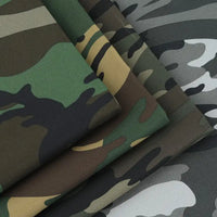Gros plan sur le tissu sergé camouflage en coton au mètre de Longan Craft France, montrant différents motifs de couleur - vert, brun, noir, tan, gris - idéal pour les pantalons, les vestes, les chaussures et les casquettes.