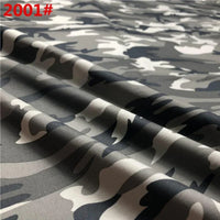 Gros plan sur le tissu de coton sergé camouflage de Longan Craft France, qui présente des motifs gris, noirs et blancs avec des plis. La mention rouge "2001#" apparaît en haut à gauche. Idéal pour les pantalons, les vestes, les chaussures et les casquettes ; vendu au mètre.