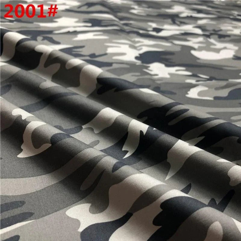 Gros plan sur le tissu de coton sergé camouflage de Longan Craft France, qui présente des motifs gris, noirs et blancs avec des plis. La mention rouge "2001#" apparaît en haut à gauche. Idéal pour les pantalons, les vestes, les chaussures et les casquettes ; vendu au mètre.