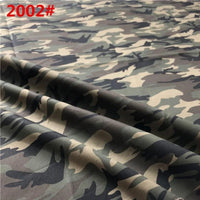 Un gros plan du Tissu sergé camouflage en coton de Longan Craft France montre des motifs verts, bruns et noirs avec "2002#" en rouge en haut à gauche. Le tissu brossé apparaît plié, mettant en valeur sa texture - idéal pour les pantalons, les gilets, les chaussures et les casquettes.