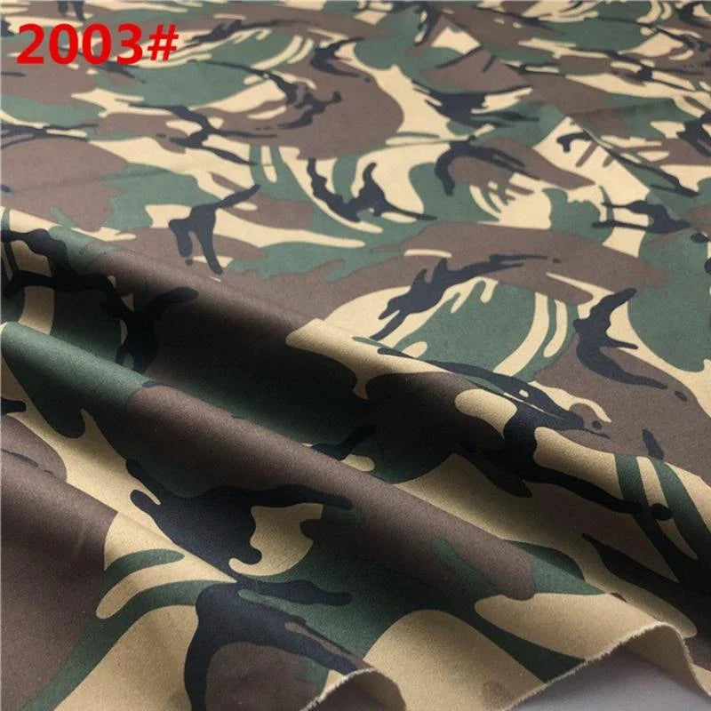 Gros plan sur le tissu sergé camouflage en coton au mètre de Longan Craft France, avec un motif irrégulier vert, marron, beige et noir ; "2003#" est indiqué en rouge dans le coin supérieur gauche. Idéal pour les pantalons, gilets, chaussures et casquettes.