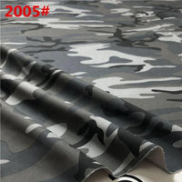 Gros plan sur le tissu sergé camouflage en coton au mètre de Longan Craft France, montrant son motif brossé gris, noir et blanc avec "2005#" en texte rouge en haut à gauche ; le tissu est plié librement pour mettre en évidence sa texture.