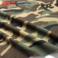 Un gros plan du tissu sergé camouflage en coton au mètre de Longan Craft France montre des nuances de vert, de brun, de beige et de noir avec "2007#" en rouge en haut à gauche ; le tissu légèrement froissé met en évidence sa qualité de couture résistante.