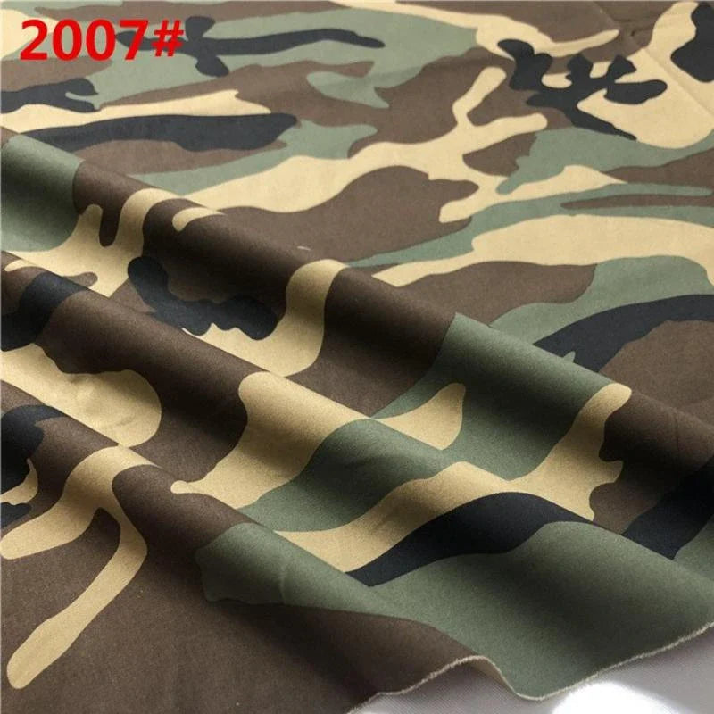 Un gros plan du tissu sergé camouflage en coton au mètre de Longan Craft France montre des nuances de vert, de brun, de beige et de noir avec "2007#" en rouge en haut à gauche ; le tissu légèrement froissé met en évidence sa qualité de couture résistante.