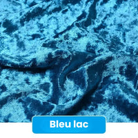 Gros plan sur un Tissu en velours froissé au mètre de Longan Craft France, froissé et brillant, d'un bleu éclatant. Une étiquette au bas de l'emballage indique "Bleu lac" en texte blanc sur fond bleu.