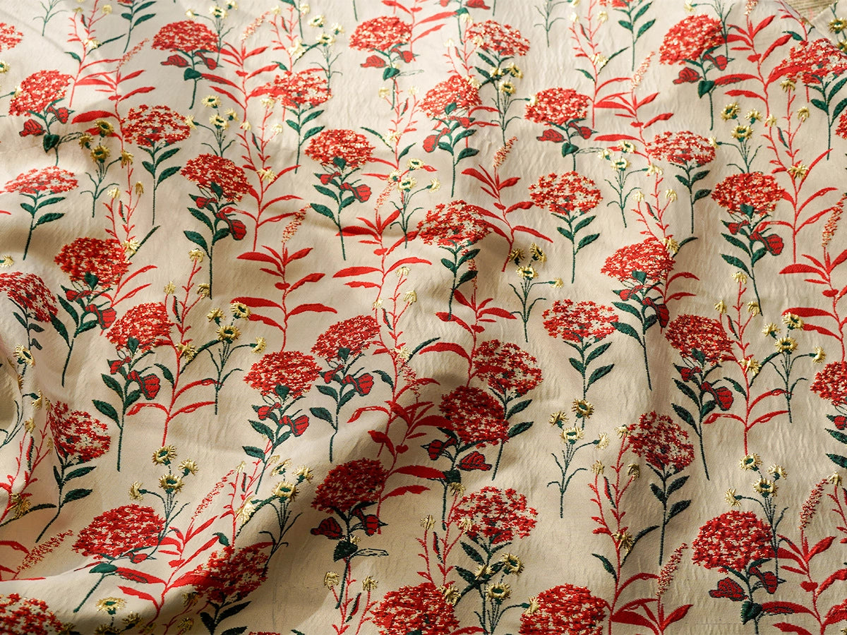 Le tissu brocart pissenlit brodé de Longan Craft France est un tissu d'ameublement jacquard floral de style ancien, qui présente des fleurs rouges et jaunes avec des tiges vertes sur fond beige, avec une surface subtilement ridée et des ombres douces et élégantes à la lumière.