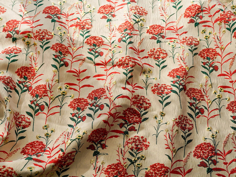 Le tissu brocart pissenlit brodé de Longan Craft France est un tissu d'ameublement jacquard floral de style ancien, qui présente des fleurs rouges et jaunes avec des tiges vertes sur fond beige, avec une surface subtilement ridée et des ombres douces et élégantes à la lumière.