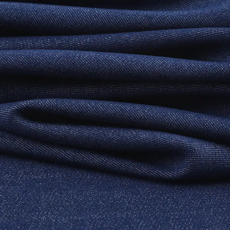 Gros plan sur les plis du tissu sergé de viscose coloris denim Longan Craft France, révélant sa texture et son motif en diagonale-idéal pour confectionner des vestes élégantes avec cette matière extensible chic.