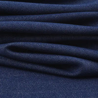 Gros plan sur les plis du tissu sergé de viscose coloris denim Longan Craft France, révélant sa texture et son motif en diagonale-idéal pour confectionner des vestes élégantes avec cette matière extensible chic.