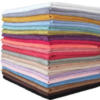 Une pile colorée de tissu suédine double face au mètre de Longan Craft France, disponible en jaune, bleu, vert, rouge, rose, violet, beige, marron, gris, noir et blanc - idéal pour les housses de canapé, les sacs et les doublures.
