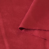 Un gros plan du tissu suédine double face au mètre de Longan Craft France montre sa surface douce et texturée en microfibre. Un coin est plié pour révéler le dessous en imitation cuir suédé, idéal pour les housses de canapé, les sacs et les doublures.