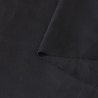 Gros plan sur le tissu suédine noir double face au mètre de Longan Craft France, montrant un coin plié et mettant en valeur sa texture microfibre douce et mate, idéale pour les housses de canapés, les sacs et les doublures.