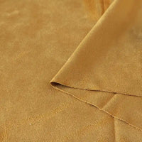 Un gros plan du tissu suédine double face au mètre de Longan Craft France montre sa surface en microfibre brun doré et son coin plié, révélant les deux côtés - idéal pour les housses de canapés, les sacs et les doublures.