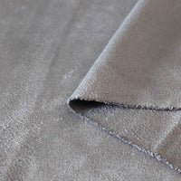 Un gros plan du tissu suédine double face au mètre de Longan Craft France montre un coin plié, mettant en évidence la texture douce de la microfibre et la finition en faux daim, idéale pour les housses de canapé, les sacs et les doublures.