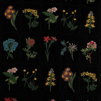 Le Tissu coton brodé de motifs floraux de Longan Craft France présente des carreaux colorés ornés de fleurs brodées sur fond noir, idéal pour des vêtements uniques ou des projets déco grâce à sa matière douce.