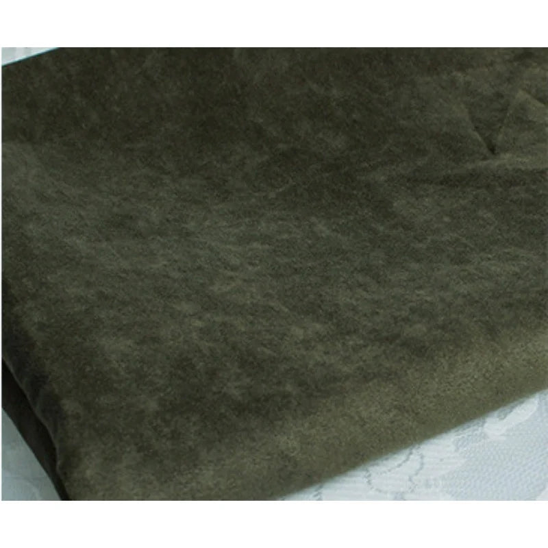 Un gros plan de Suédine unie embossée au mètre de Longan Craft France montre son tissu synthétique doux et embossé de couleur vert olive, posé à plat, avec une texture luxueuse et légèrement duveteuse, idéale pour les vêtements haut de gamme.