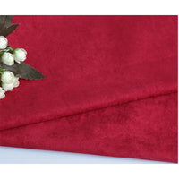 Gros plan sur la Suédine unie embossée au mètre de Longan Craft France, un tissu simili cuir rouge à la texture douce, présenté à côté de fleurs artificielles blanches et de feuilles vertes dans un coin.