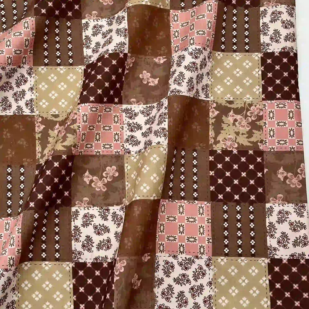 Gros plan sur le Linon de coton imprimé floral ethnique au mètre de Longan Craft France, qui présente un patchwork de tons bruns, beiges, blancs et roses avec des imprimés floraux, des pois et des motifs géométriques, idéal pour les vêtements de style vintage.