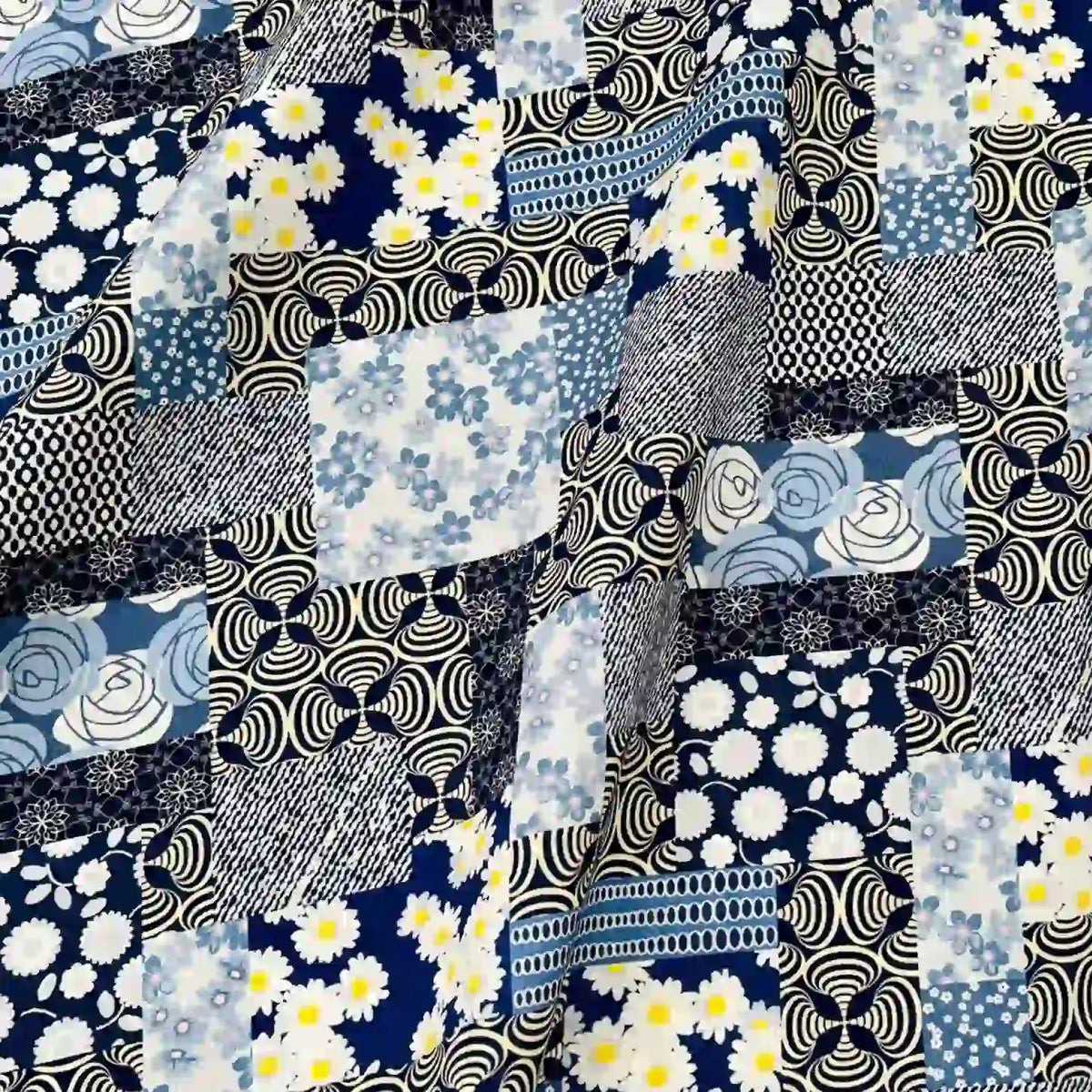 Découvrez le Linon de coton imprimé floral ethnique au mètre de Longan Craft France, un linon de coton au style vintage avec un patchwork de carrés bleus, blancs et noirs, de marguerites, de tourbillons et de fleurs. Texture légèrement froissée, idéale pour l'habillement.