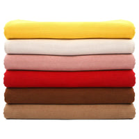 Une pile de six pulls côtelés de couleur jaune, blanc cassé, rose, rouge, marron et beige en Tissu velours côtelé à fines côtes au mètre de Longan Craft France est disposée horizontalement sur un fond blanc.