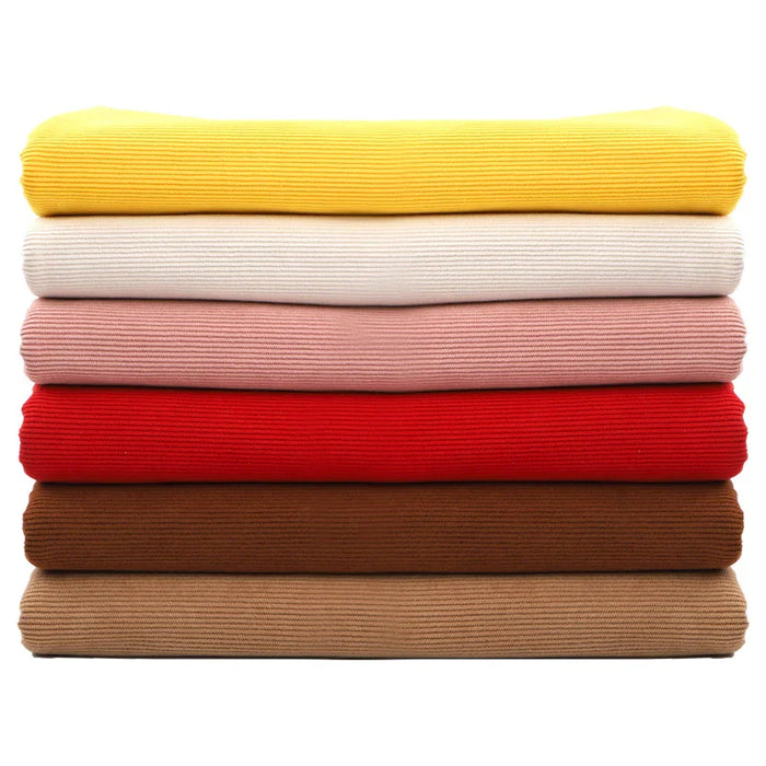 Une pile de six pulls côtelés de couleur jaune, blanc cassé, rose, rouge, marron et beige en Tissu velours côtelé à fines côtes au mètre de Longan Craft France est disposée horizontalement sur un fond blanc.