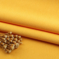 Un gros plan montre le tissu velours côtelé à fines côtes au mètre de Longan Craft France avec un petit bouquet de fleurs séchées sur le dessus, mettant en valeur la texture fine du velours côtelé - idéal pour les canapés, les vêtements et les pantalons.