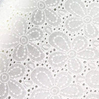 Tissu œillet brodé floral au mètre de Longan Craft France : coton blanc léger à motifs fleuris, détails ajourés et texture délicate.