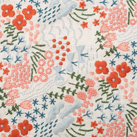 Tissu brodé floral au mètre de Longan Craft France en coton lin, avec fleurs rouges, roses et bleues, feuilles vertes et motifs bleus sur fond crème-idéal pour décoration intérieure ou couture.