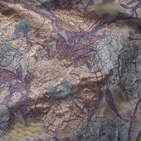 Gros plan sur le Tissu organza brodé floral au mètre de Longan Craft France, un organza transparent avec de grandes fleurs et feuilles de couleur lavande, beige et bleu clair, avec un subtil reflet métallique - idéal pour les robes.